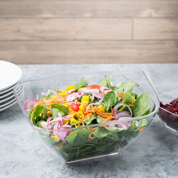 A salad in a clear acrylic bowl.