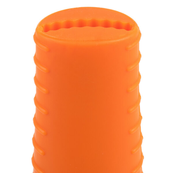 An orange cylindrical silicone handle holder with a cut out design on a white background.