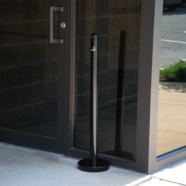 a black pole in front of a glass door