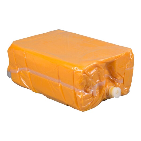 A large rectangular yellow bag filled with a substance, sealed in clear plastic with a white spout on one end.