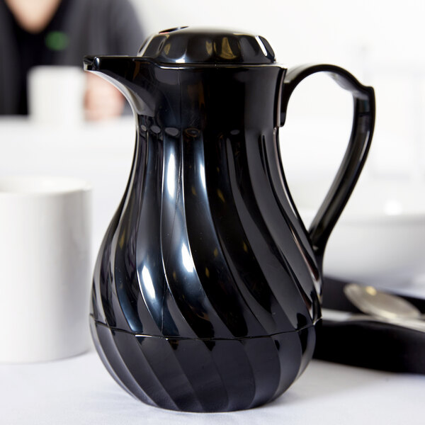 A black Vollrath SwirlServe hot-n-cold beverage server on a table.