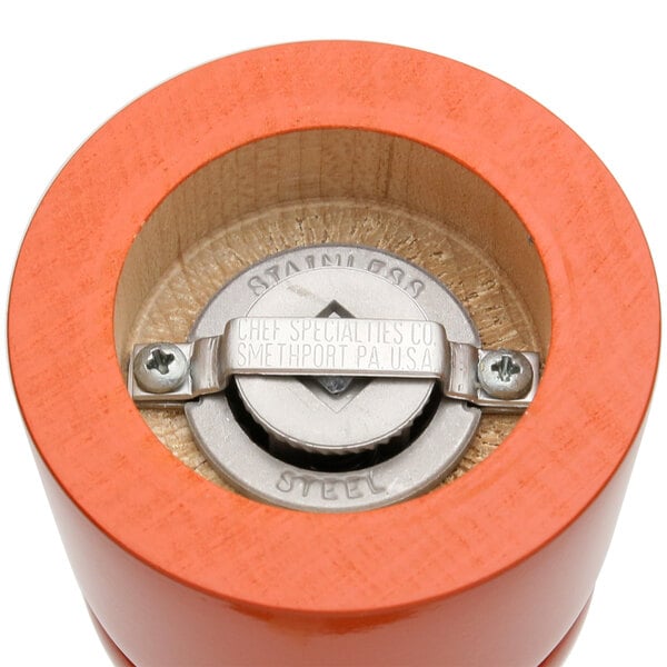 A close-up of a Chef Specialties Butternut Orange pepper mill and salt mill set on a table.