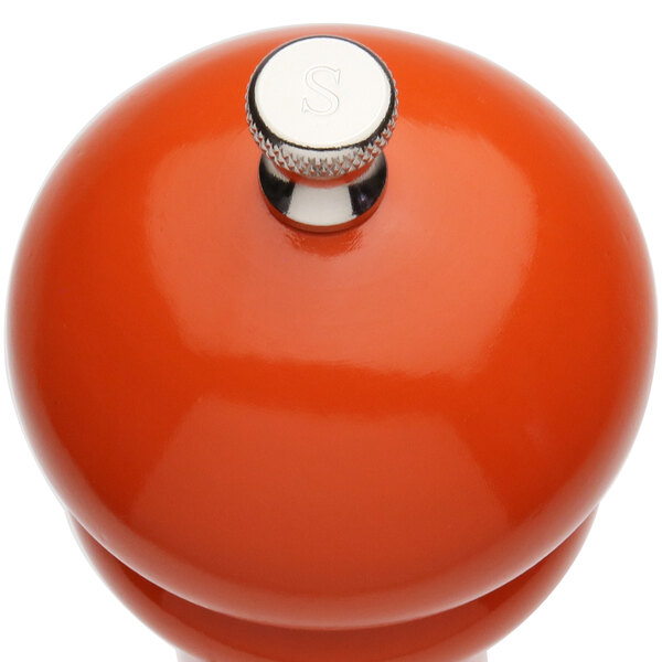 A Chef Specialties butternut orange pepper mill with a silver top.
