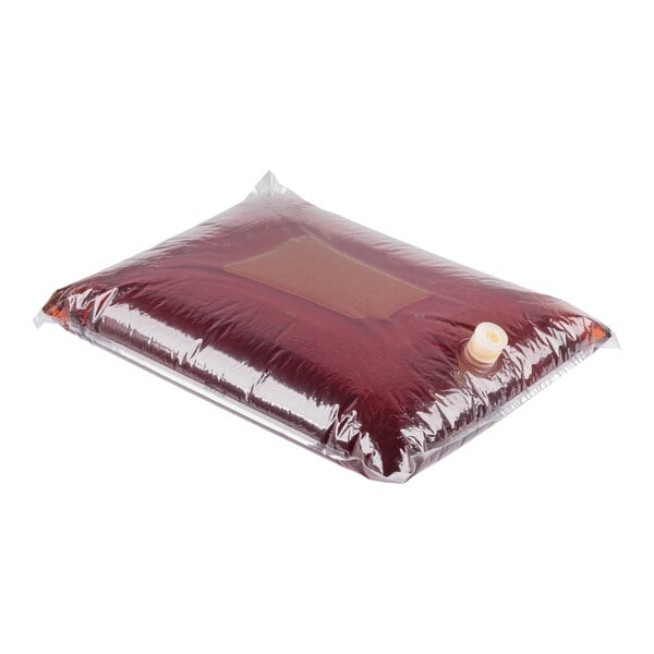 A transparent plastic bag filled with a dark red liquid and sealed with a white cap, lying on a white surface.