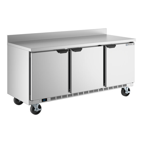 A stainless steel three-door worktop refrigerator with a 4-inch foamed-in-place backsplash and casters.