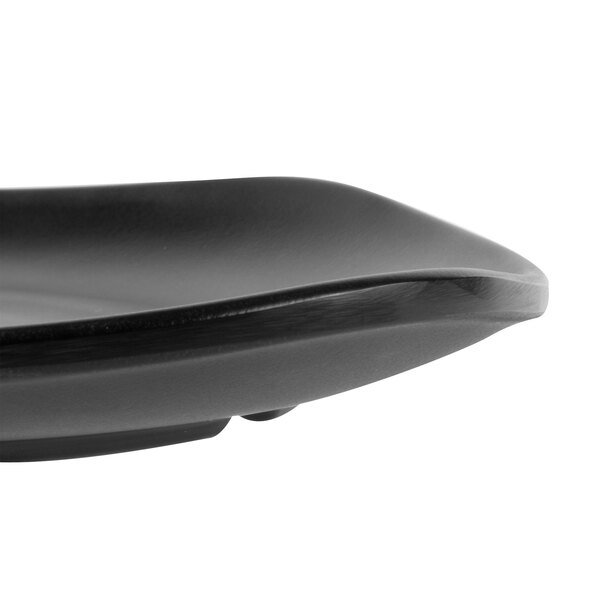 A close-up of a black GET Nara square melamine plate with a curved edge.
