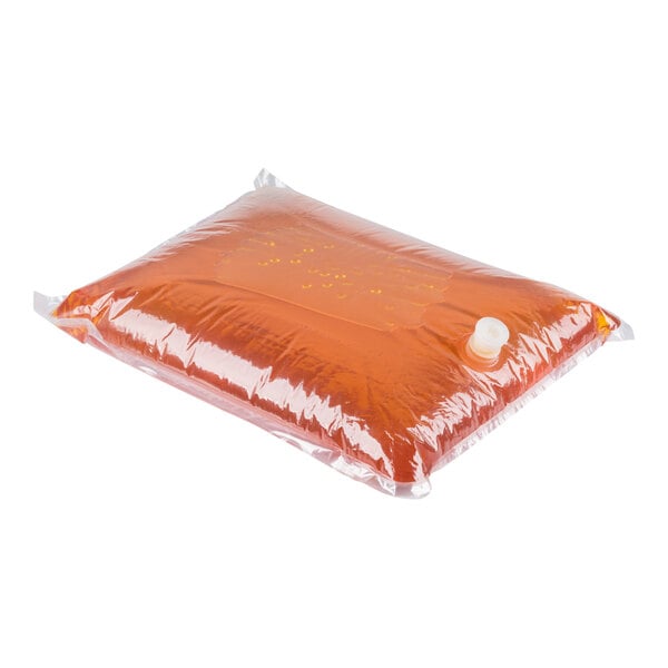 A clear plastic bag filled with orange liquid and sealed with a white cap, resting on a white background.