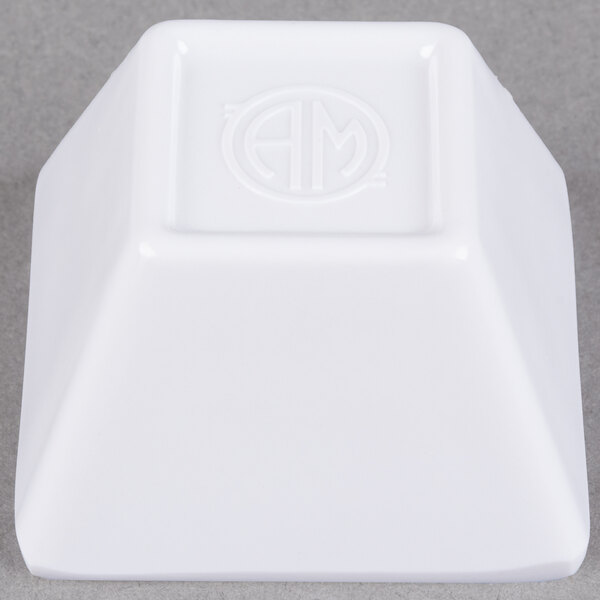 A white square American Metalcraft sauce cup with a logo on it.