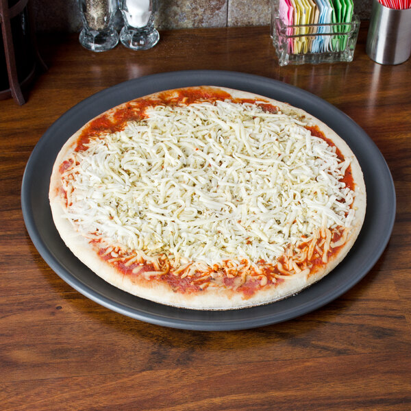 A pizza on a American Metalcraft Hard Coat Anodized Aluminum Pizza Pan with cheese on it.