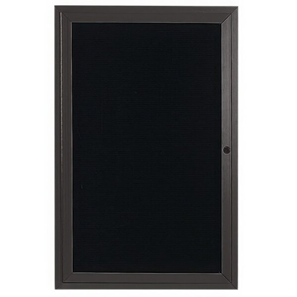 A bronze rectangular board with a black door and black letter board inside.