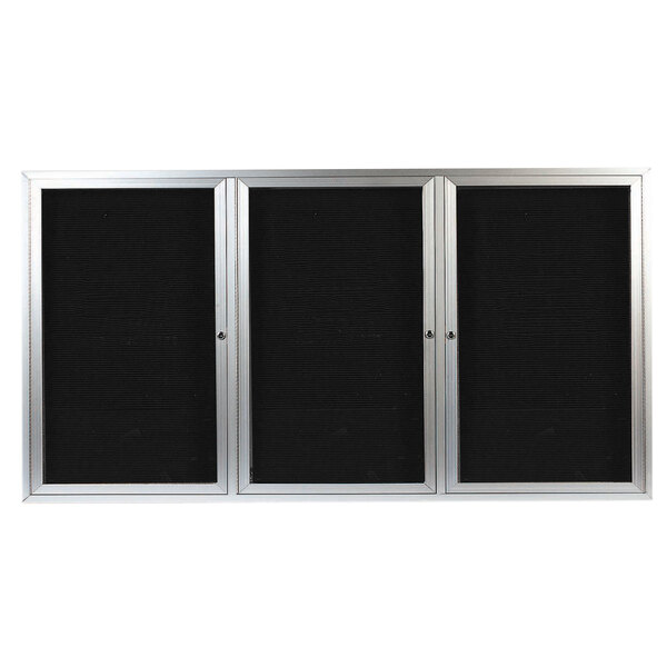 A black rectangular object with a silver frame and three black letter boards behind glass doors.