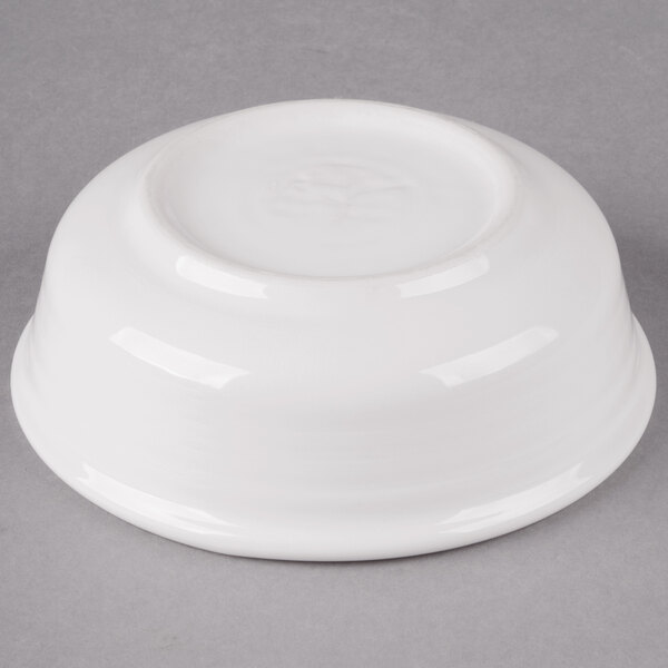 A Fiesta white China Nappy bowl on a gray surface.
