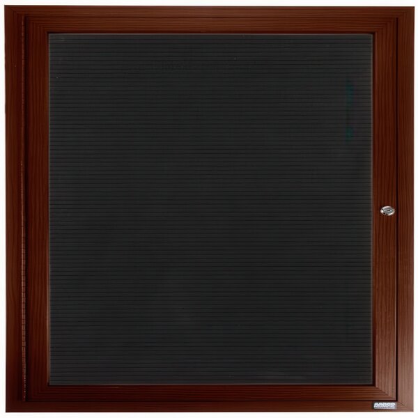 An Aarco outdoor directory board with a walnut frame and black vinyl letter board behind a wooden door with a lock.