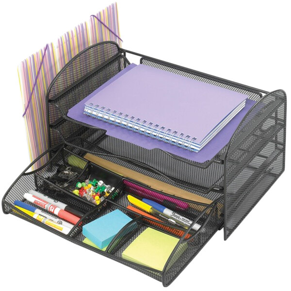 A black Safco wire mesh desk organizer with sections holding pens and stationery.