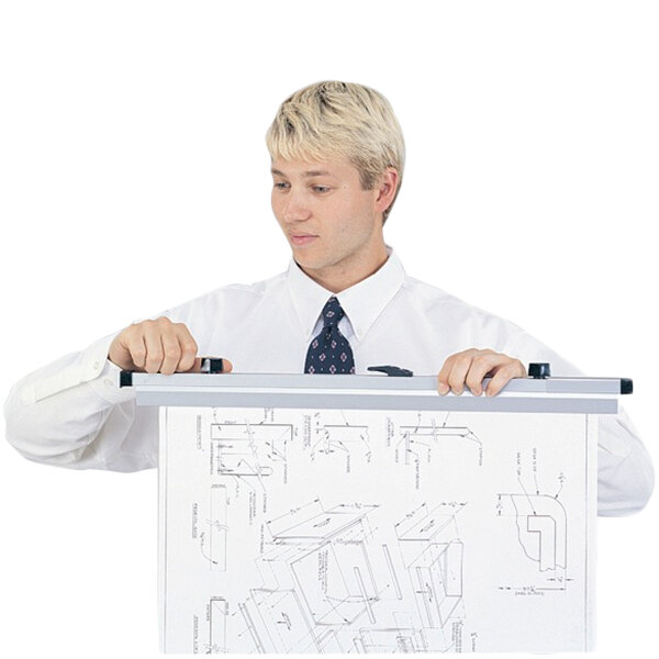 A man using Safco paper clamps to hold a blueprint.