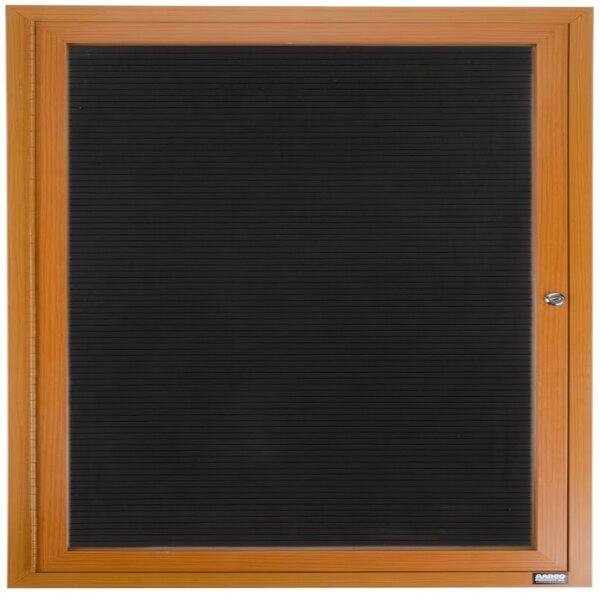 An Aarco oak enclosed bulletin board with black felt on the inside of the door.