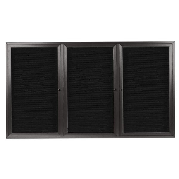 A black rectangular Aarco directory board with three black doors with glass panels.
