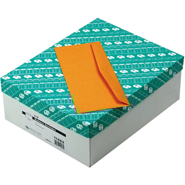 A box of Quality Park brown Kraft business envelopes with one envelope on it.