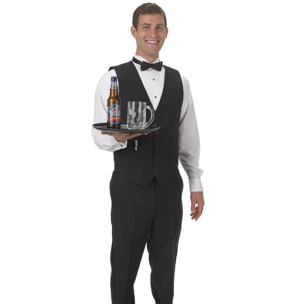 A man in a Henry Segal black server vest holding a tray with a beer and a mug.