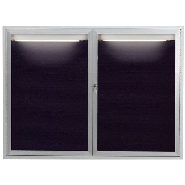 A black rectangular Aarco outdoor message center with a light on it.