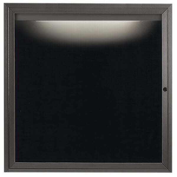 A black square frame with a light on it holding a black letter board.