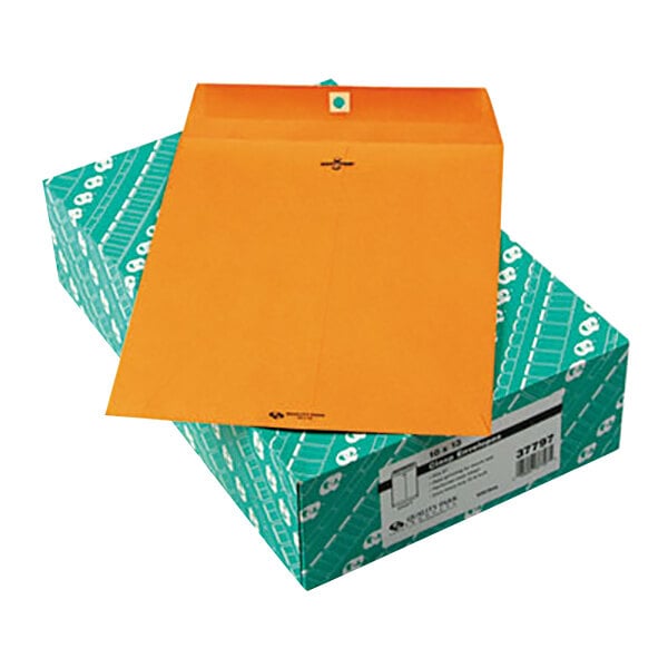 A box of Quality Park brown Kraft file envelopes with an orange envelope on top.