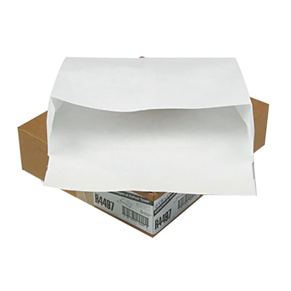A brown box with a white envelope sitting on top.