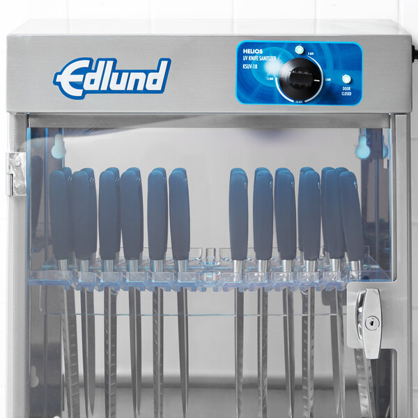 A metal cabinet with knives in it.