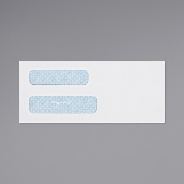 A close-up of a white Quality Park check envelope with blue labels and a blue and white diamond pattern.