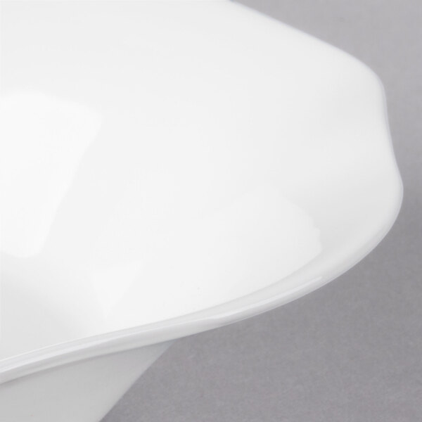A close up of a Villeroy & Boch white bone porcelain deep plate with a curved edge.