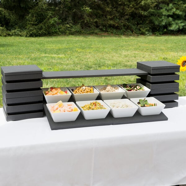 A table with a white Vollrath Cubic bowl of food on it.