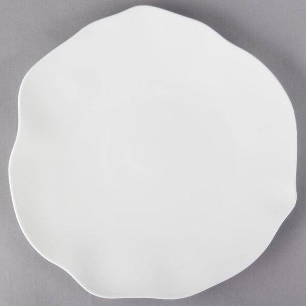 A white Villeroy & Boch bone porcelain flat plate with a small design on it.