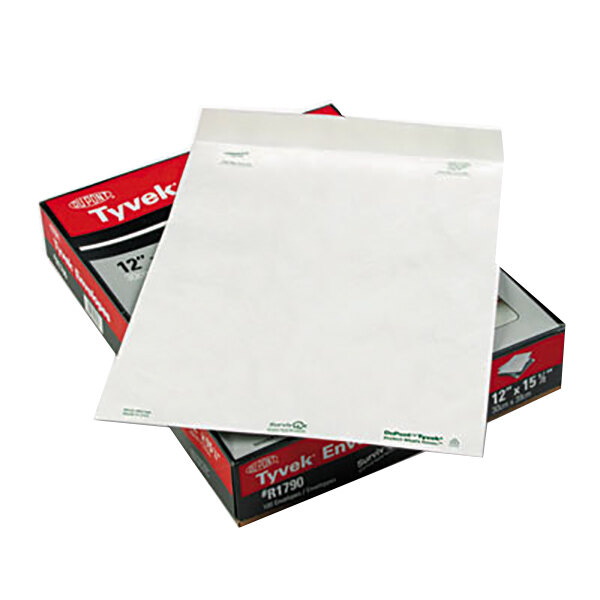 A box of white Survivor Tyvek mailers with green labels on top.
