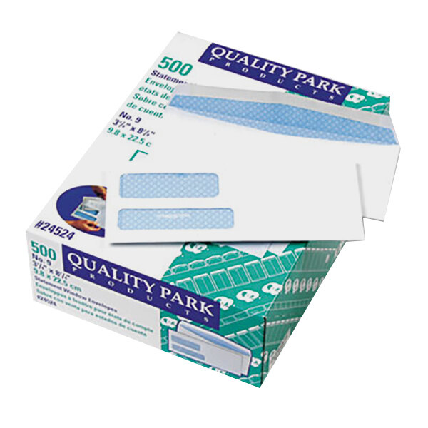 A box of white Quality Park envelopes with blue and green labels.
