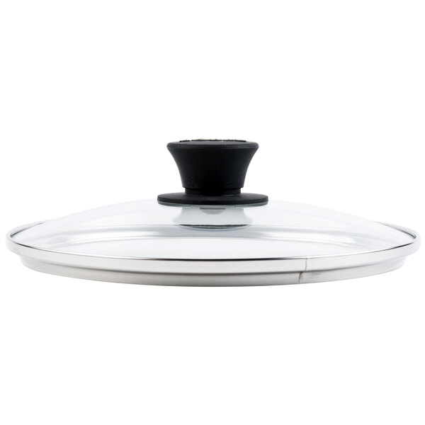 A close-up of a Lodge glass lid with a black handle.