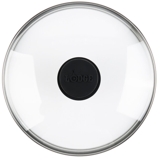 A clear glass lid with a black circle.