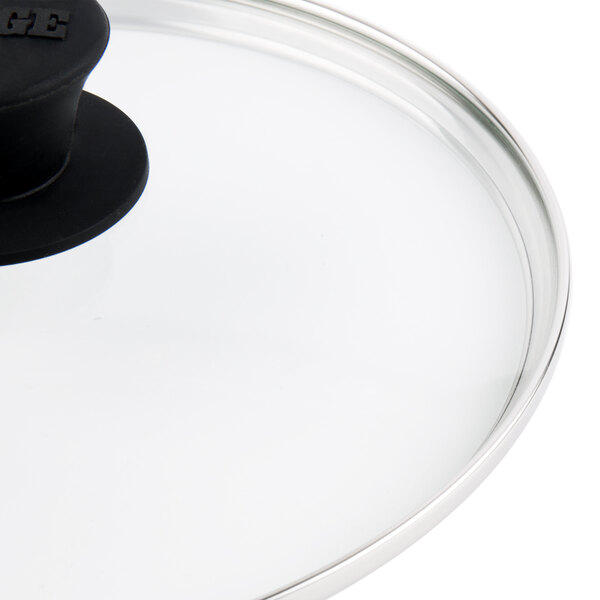 A close-up of a Lodge tempered glass lid with a black handle.