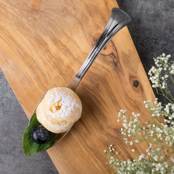 A Bon Chef stainless steel sombrero tasting spoon with dessert on it.