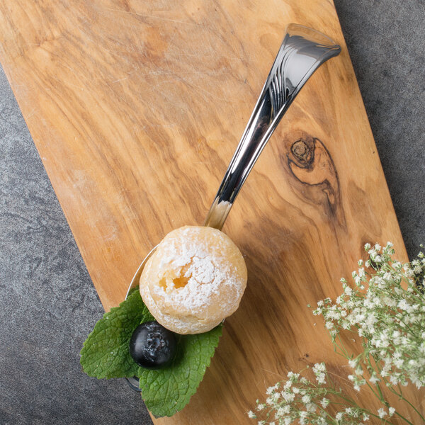 A Bon Chef silver soup/dessert tasting spoon with food on it.
