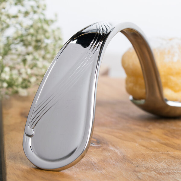 A Bon Chef silver spoon with a wave design on a table.