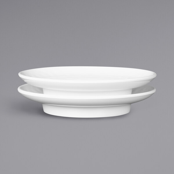 A white Elite Global Solutions Ming melamine plate with a stack of plates on it.