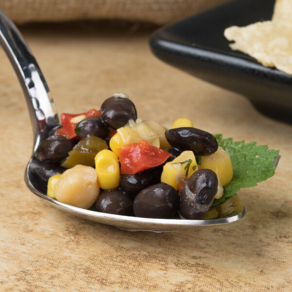 A Bon Chef Reflections silver spoon filled with food on a counter.