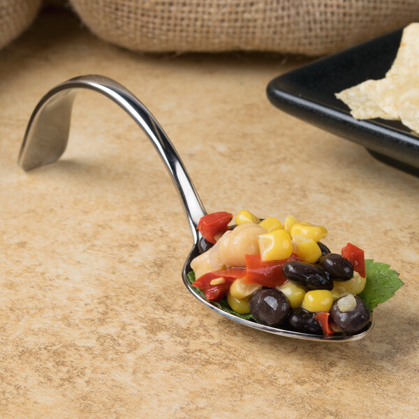 A Bon Chef stainless steel spoon full of food on a table.