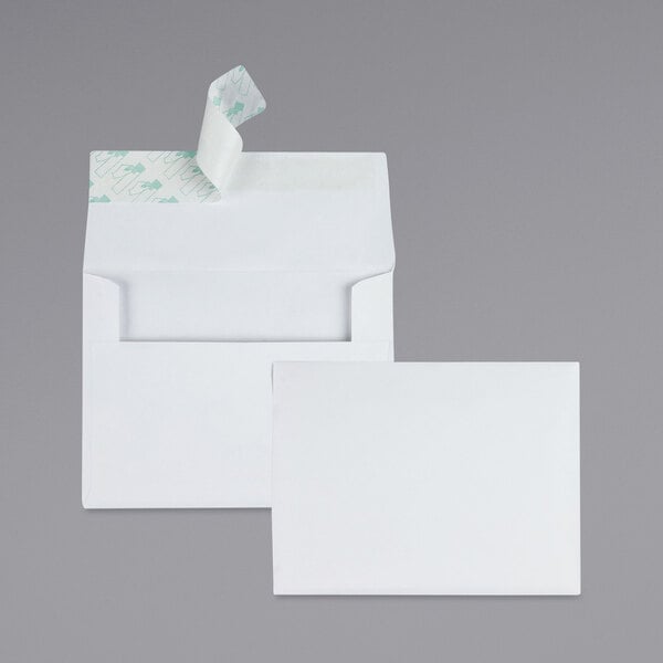 A close-up of two white Quality Park envelopes with a red and white strip on them.