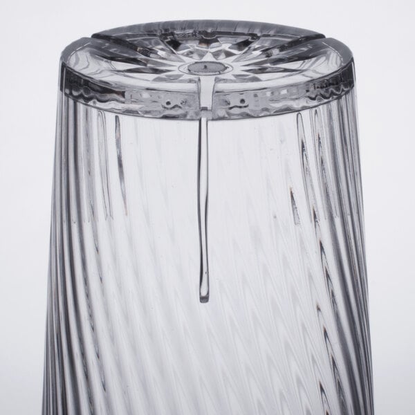 A close up of a Thunder Group clear polycarbonate tumbler with a drop of water on it.