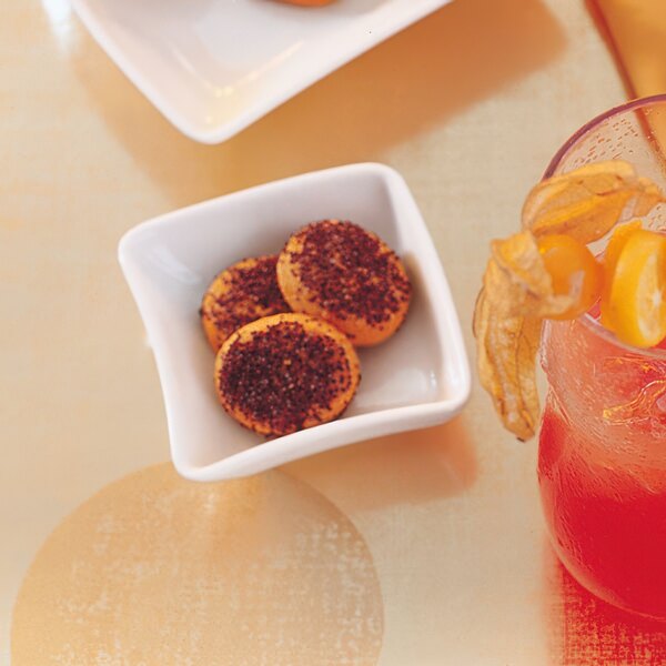 A bowl of food with red sprinkles on a table.