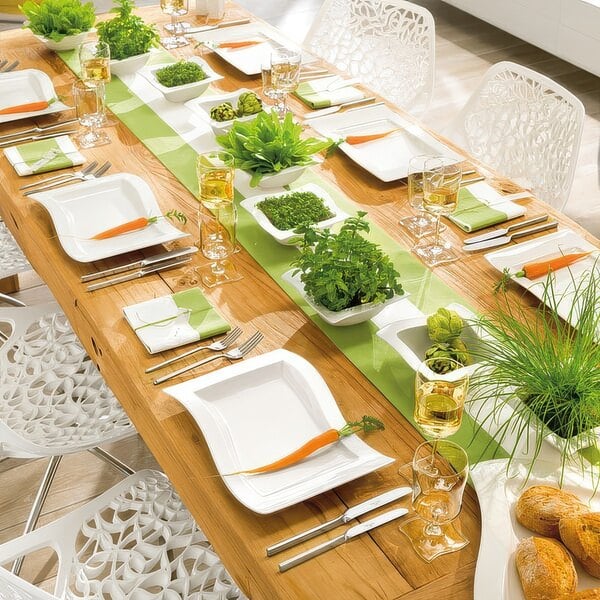 A table set with rectangular white Villeroy & Boch porcelain plates and green napkins.