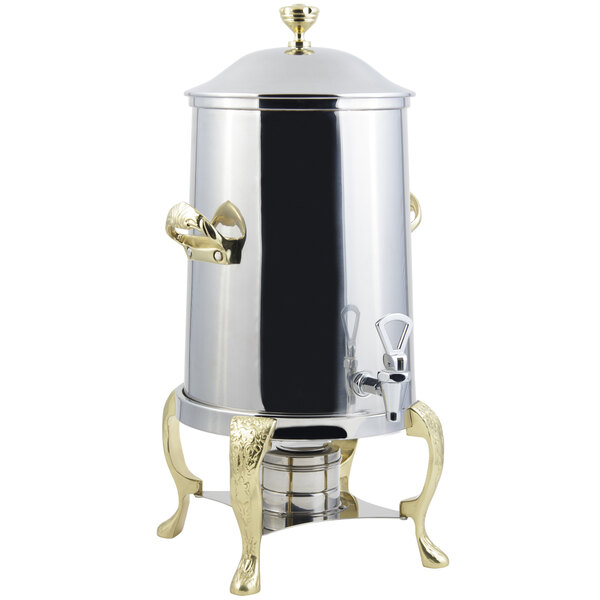 A stainless steel coffee chafer urn with brass trim.