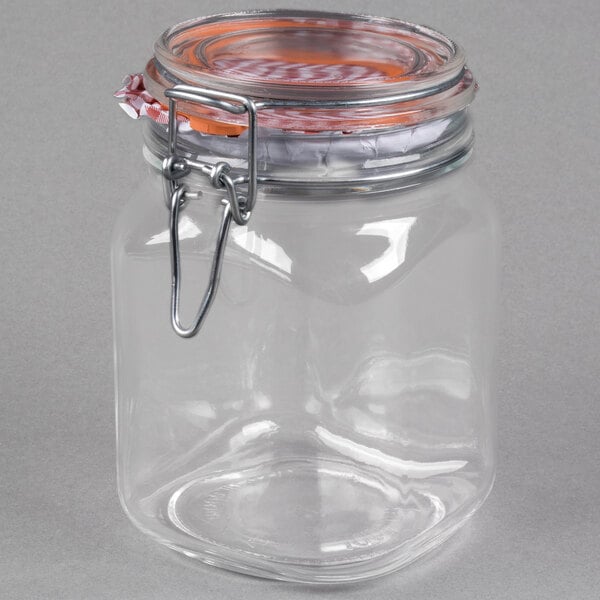 A clear glass jar with a metal lid and a metal clip.