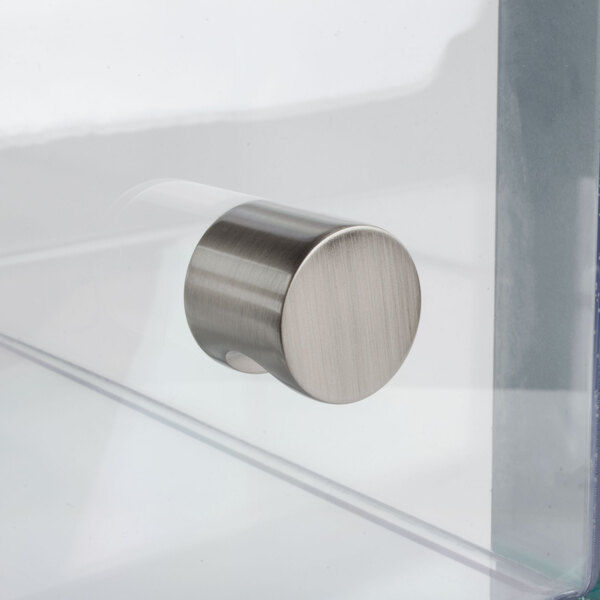 A close-up of a metal knob on a clear drawer.